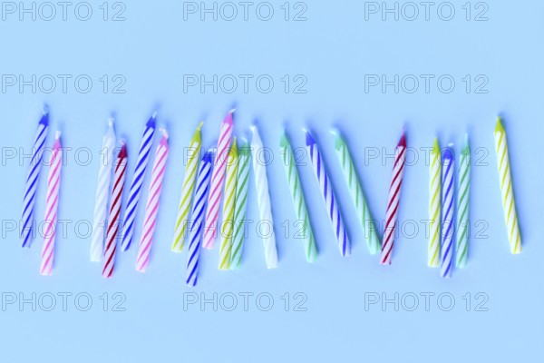 Row of colorful birthday candles on blue background