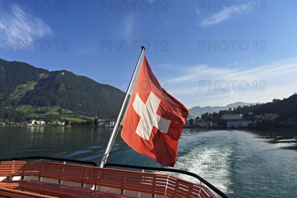 Swiss flag in the stern of the motor ship Brunnen in motion, Lake Lucerne, Brunnen, Canton, Schwyz, Switzerland