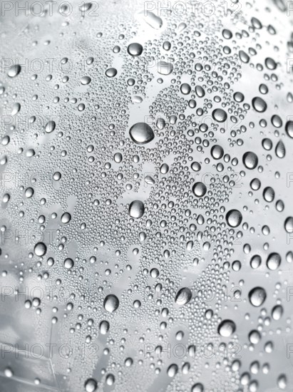 Drops of water on plastic bottle, neutrally illuminated, detailed view