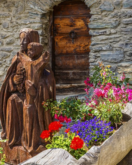 Carved wooden figure of the Virgin Mary with the infant Jesus, wooden trough decorated with flowers, Ayer, Val d'Anniviers, Valais Alps, Canton Valais, Switzerland