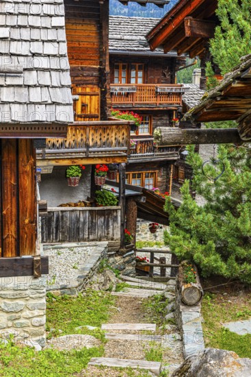 Winding wooden houses with flower-decorated balconies in the historic centre of Grimentz, Val d'Anniviers, Valais Alps, Canton Valais, Switzerland