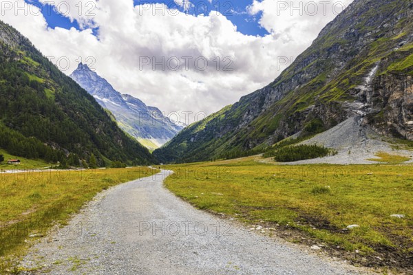 Hiking trail in the Zinal valley, behind the mountain Besso with its twin peaks, Val d'Anniviers, Valais Alps, Canton Valais, Switzerland