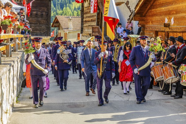Drummers' and pipers' meeting in Mission, here the Echo des Alpes brass band marching in, led by a standard-bearer, Val d'Anniviers, Valais Alps, Canton Valais, Switzerland