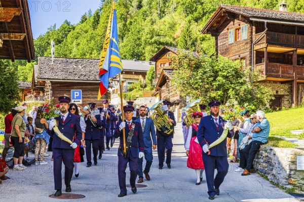 Drummers' and pipers' meeting in Mission, here the Echo des Alpes brass band marching in, led by a standard-bearer, Val d'Anniviers, Valais Alps, Canton Valais, Switzerland