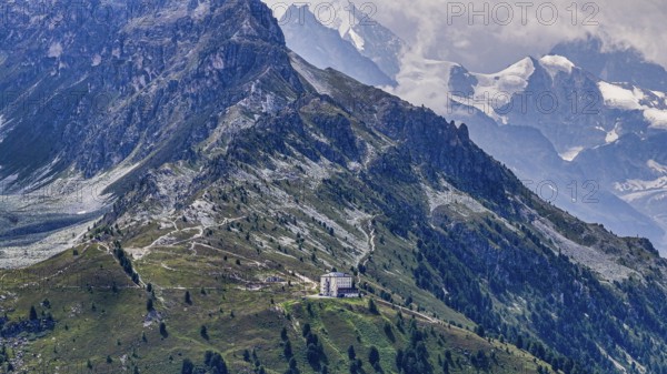 The historic Hotel Weisshorn below the Weisshorn mountain, behind the four-thousand-metre peaks and glaciers in clouds, above the mountain village of Zinal, drone shot, Val d'Anniviers, Valais Alps, Canton Valais, Switzerland