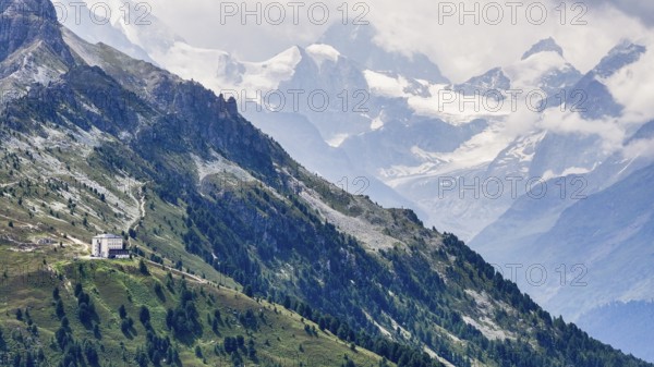 The historic Hotel Weisshorn below the Weisshorn mountain, behind the four-thousand-metre peaks and glaciers in clouds, above the mountain village of Zinal, drone shot, Val d'Anniviers, Valais Alps, Canton Valais, Switzerland