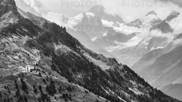 The historic Hotel Weisshorn below the Weisshorn mountain, behind the four-thousand-metre peaks and glaciers in clouds, drone shot, black and white image, Val d'Anniviers, Valais Alps, Canton Valais, Switzerland