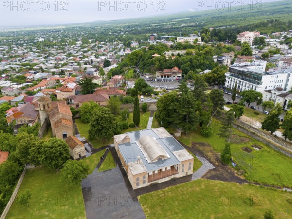 Historic buildings surrounded by greenery in an urban landscape under a cloudy sky, aerial view, Royal Palace in Batonis Ziche, Batonistsikhe, Royal Fortress, Telavi, Telavi, Kakheti region, Georgia