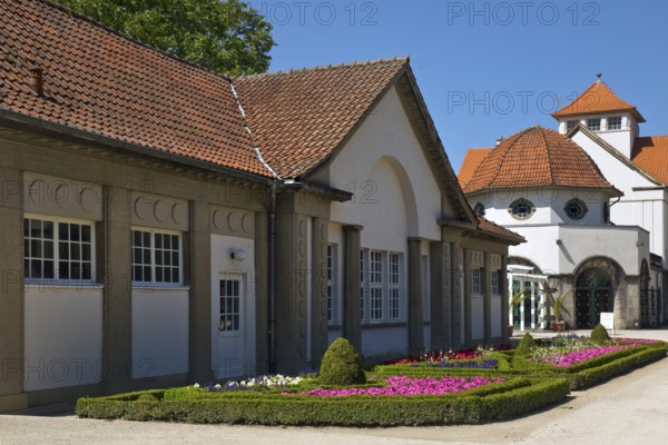 Rose garden in the spa gardens with the back of the concert shell and the Trinkkuranlage, Bad Nauheim, Hesse, Germany