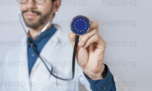 Doctor holding stethoscope with European Union flag. European Union health and care concept, European Union flag on stethoscope
