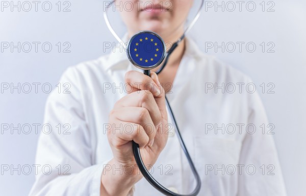 Female doctor holding stethoscope with European Union flag. National health system of European Union