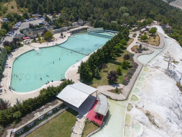 Large swimming pool with park in green landscape, people enjoying the facility, aerial view, Akkaya Travertines, Bolu Province, Turkey
