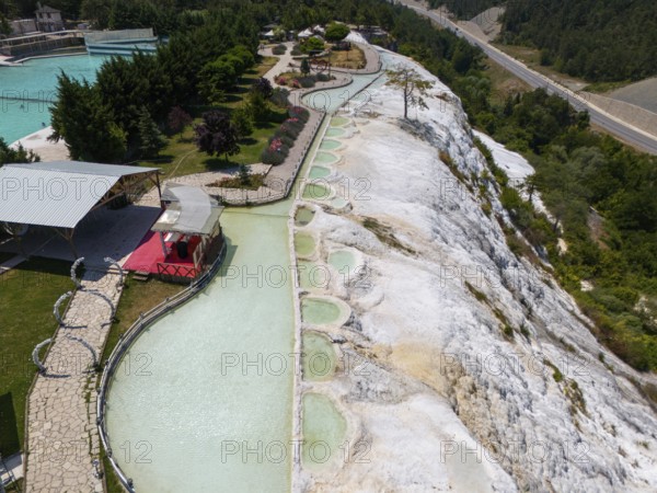 Limestone terraces with flowing water in the middle of a green landscape, aerial view, Akkaya Travertines, Bolu Province, Turkey
