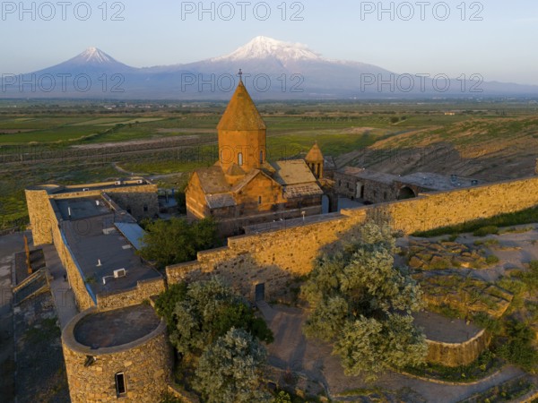A historic monastery in the morning light in front of Mount Ararat, aerial view, Chor Wirap monastery, Chor Virap, deep dungeon, in the background Mount Ararat and Little Ararat, located in Turkey, Ararat province, Armenia