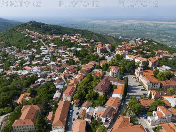 Aerial view of a hilly town with red roofs and green trees surrounded by a vast landscape, aerial view, Sighnaghi, Signagi, Kakheti Province, Greater Caucasus, Georgia, Near East