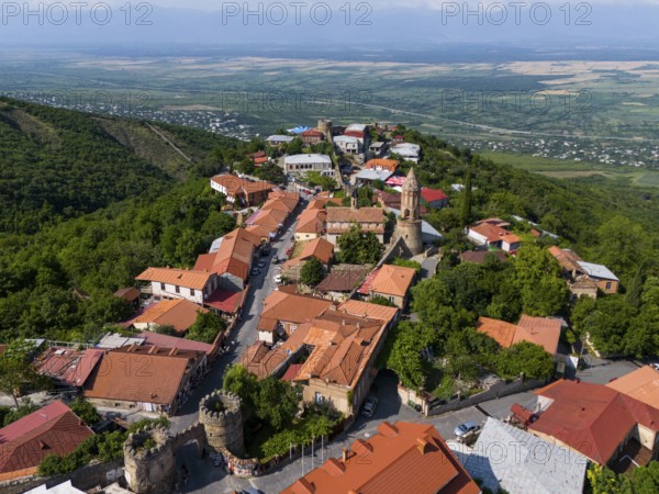 Surrounded by hills lies a picturesque village with tiled roofs and a church overlooking the valley, aerial view, town gate, Sighnaghi, Signagi, Kakheti Province, Greater Caucasus, Georgia, Near East