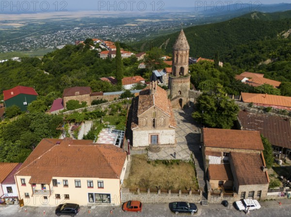 Village view with church tower and brick buildings, surrounded by green hills and wide landscape, aerial view, Church of St George, St George, Sighnaghi, Signagi, Kakheti Province, Greater Caucasus, Georgia, Near East