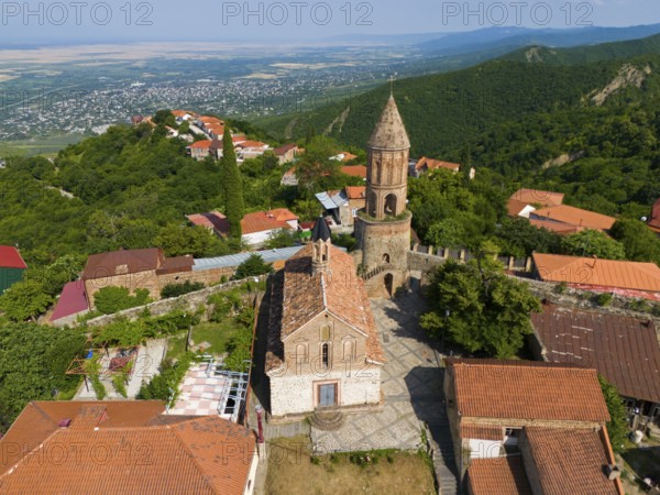 Historic church with tower in a village surrounded by mountains with red tiled roofs, aerial view, Church of St George, St George, Sighnaghi, Signagi, Kakheti Province, Greater Caucasus, Georgia, Near East