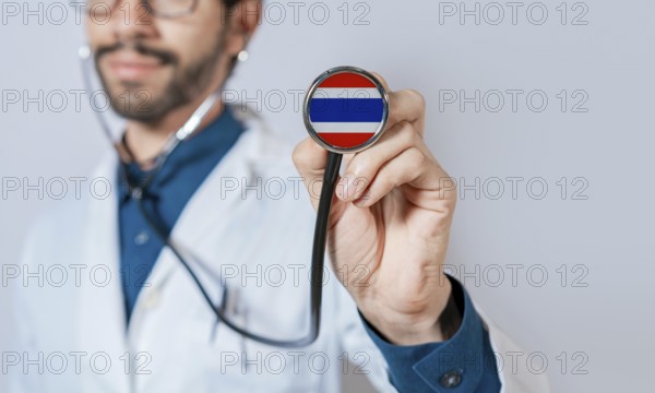 Doctor holding stethoscope with Thailand flag. Thailand health and care concept, Thailand flag on stethoscope