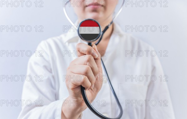 Female doctor holding stethoscope with Yemen flag. National health system of Yemen