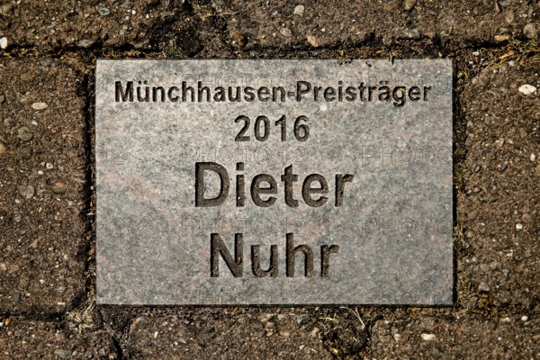 Sign for the 2016 Münchhausen Prize winner Dieter Nuhr in the Münchhausen town of Bodenwerder, Weserbergland, Lower Saxony, Germany