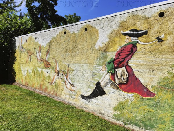 Painting on a wall Münchhausen on a duck hunt in the Münchhausen town of Bodenwerder, Weserbergland, Lower Saxony, Germany