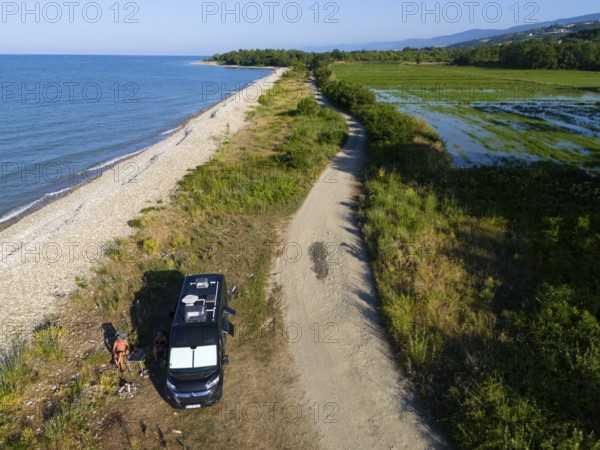 A van parked on a beach along a coastal road with lush vegetation and sea view, aerial view, camper, motorhome, rice paddies near Sancakli, Sancakli, Terme, Samsun province, Turkey