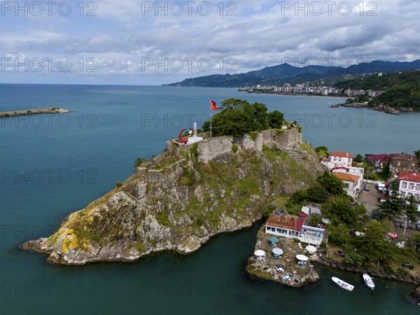 Castle on a rock formation near coastal houses and mountains with clouds, aerial view, fortress, castle, Tirebolu, Giresun Province, Black Sea, Turkey