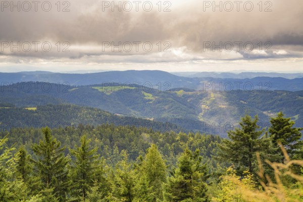 Expansive view of forested mountains under a cloud cover with a misty touch, Mummelsee, Seebach, Ortenau district, Black Forest, Germany