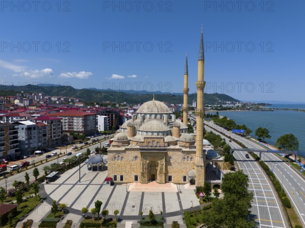 Large mosque with several minarets on the coast, surrounded by modern buildings and mountains in the background, aerial view, Sarayburnu Mosque, Sarayburnu Cami, largest mosque outside Instanbul in Turkey, Bulancak, Giresun Province, Turkey