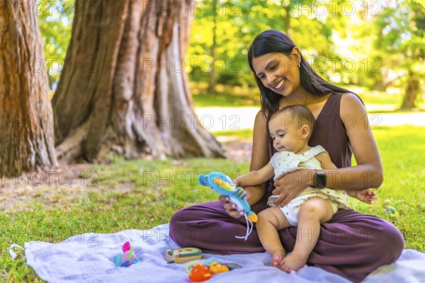 Latin mother and daughter enjoying a sunny day at the park, playing with colorful toys and creating a heartwarming family moment