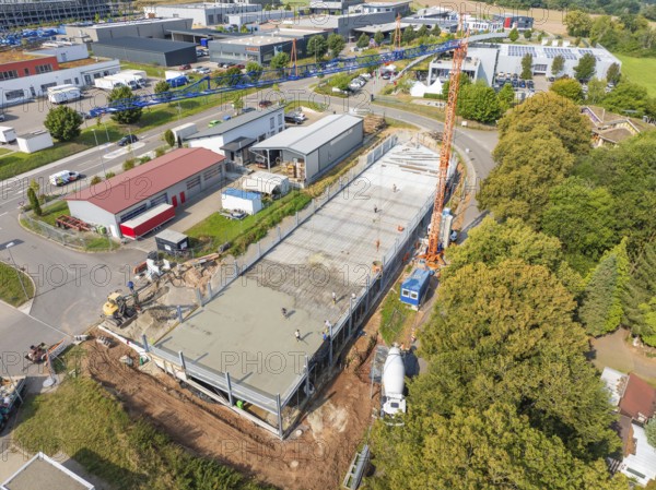 Large-scale construction site with crane and buildings in green, urban surroundings, car park construction, Calw, Germany