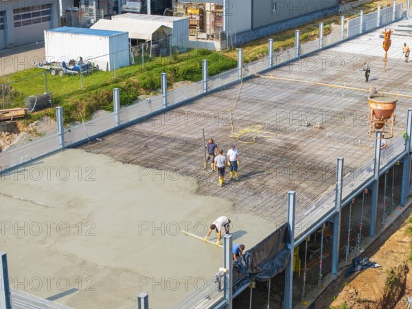 Construction workers working on a concrete surface on a building site in a green environment, car park construction, Calw, Germany