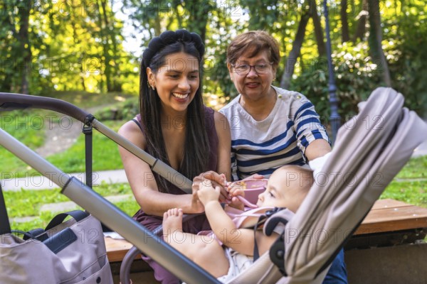 Grandmother, mother, and baby girl enjoying quality time together in a park, highlighting the joys of family and childcare
