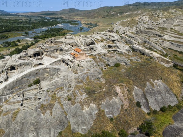 Historic cave town Uplistsikhe with impressive ruins in a green river landscape, aerial view, cave town Uplistsikhe, Uplistsikhe, river Kura or Mtkvari, Inner Kartlia region, Shida Kartli, Georgia