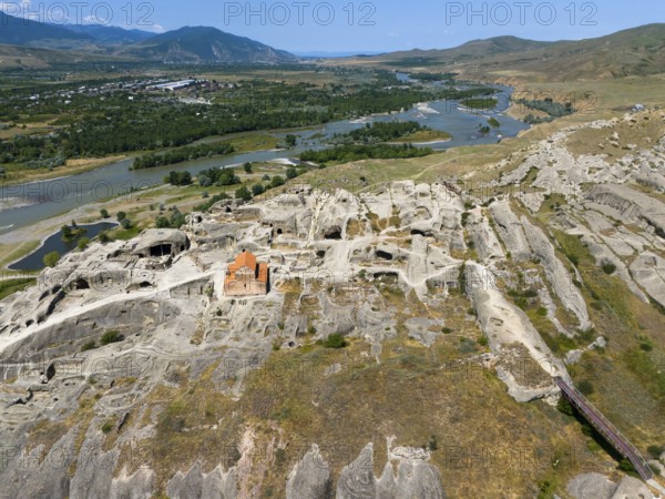 Panoramic view of a rocky landscape with embedded church and river view, aerial view, cave town Uplistsikhe, Uplistsikhe, river Kura or Mtkvari, Inner Kartlia region, Shida Kartli, Georgia