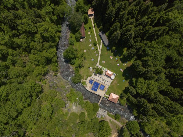 Aerial view of a forest area with swimming pool and river, surrounded by dense trees and buildings, aerial view, outdoor swimming pool, sulphur springs of Borjomi, Borjomi, Samtskhe-Javakheti region, Kura river, Lesser Caucasus, Georgia