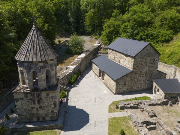 Aerial view of a monastery with stone buildings, surrounded by forest and sky in summer light, aerial view, Chitakhevi Church of St George, The Green Monastery, Mtsvane Monastery, Samtskhe-Javakheti region, Georgia