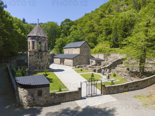 Historic monastery surrounded by lush greenery and blue sky, surrounded by ruins and vegetation, aerial view, Chitakhevi Church of St George, The Green Monastery, Mtsvane Monastery, Samtskhe-Javakheti region, Georgia