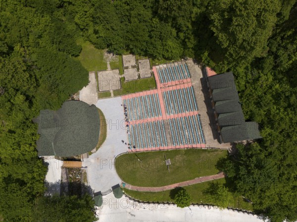 A bird's eye view of an amphitheatre with seats embedded in a wooded landscape, aerial view, Green Theatre, Tsageri, Racha-Lechkhumi region and Lower Svaneti, Georgia