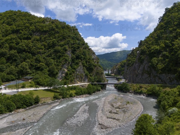 A river meanders through a wooded valley, with a bridge connecting the two banks, aerial view, Tskhenitskhali River, Tskhenitskhali, Tsageri, Racha-Lechkhumi and Lower Svaneti regions, Georgia