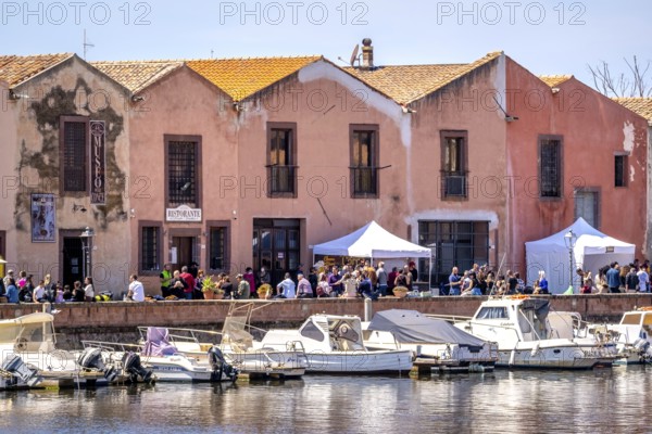 Sardinia, boats in the river Temo and houses on the promenade, guests at the restaurants with outdoor catering, Bosa, Europe, province of Oristano, Italy, old town, architecture, outdoor catering, outdoor terraces, boats, charm, diners, Europeans, river Temo, river landscape, riverside, leisure, gastronomy, guests, small town, promenade, restaurants, sightseeing, seating, summer, sun, city view, tourism, tourists, holiday, holiday resort, water, residential buildings, relaxing, historic, local, picturesque, Mediterranean, southern flair, traditional, warm