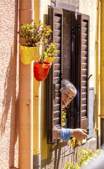 Sardinia, inhabitant looking out of a window, Bosa, Europe, Province of Oristano, Italy, everyday life, old, architecture, authenticity, observation, view, village, inhabitant, window, shutters, woman, building, Italian, landscape, lifestyle, perspective, travel, sightseeing, city, city view, stone, tourism, urban, residential building, historical, cultural, Mediterranean, curious, traditional, female
