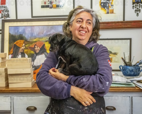 Sardinia, Pina Monne, portrait of woman and dog on arm, artist, Tinnura, Europe, province of Oristano, Italy, arm, atmosphere, expression, exhibition, relationship, bond, representation, detail, emotion, colour, woman, portrait of woman, face, pet, dog, inspiration, interior, creativity, culture, art, artwork, artist, painting, human, motif, personality, portrait, region, sightseeing, study, animal, tourism, adult, European, Italian, female