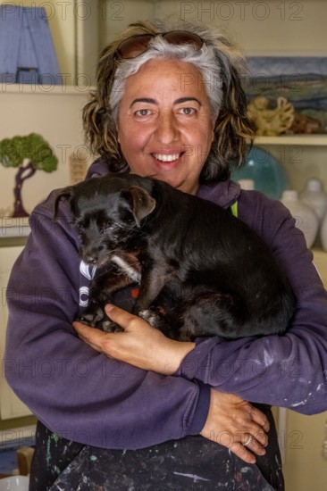Sardinia, Pina Monne, female portrait and dog on arm, artist, Tinnura, Europe, Oristano province, Italy, arm, expression, exhibition, bond, village, woman, female portrait, gallery, face, hair, pet, dog, clothing, scenery, culture, art, artwork, painting, originality, portrait, sightseeing, talent, animal, animal friendship, tourism, domesticated, adult, European, Italian, creative, Mediterranean, regional, Sardinian, traditional, female
