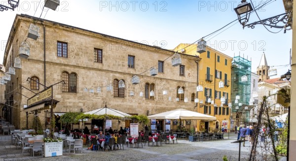 Sardinia, tourist tour group in the old town with sandstone-coloured palazzi, birdcage from house to house over the street, Alghero, Europe, Province of Sassari, Italy, lighting, IT, travel, destination, Ristorante Pizzeria Forno A Legna, sightseeing, tourism, tourist, tourist attraction, tourist trip, birdcage, tourist destination