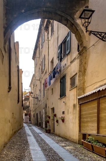 Sardinia, Narrow cobblestone alley and houses in the old town, Laundry by the window, Alghero, Europe, Province of Sassari, Italy, old building, old town, architecture, atmosphere, balconies, inhabitants, facades, windows, shutters, alley, sky, houses, cobblestones, sightseeing, summer, city, city view, stones, alleyway, daytime, tourism, urban, residential buildings, laundry, authentic, charming, narrow, European, historic buildings, picturesque, Mediterranean, quiet, traditional