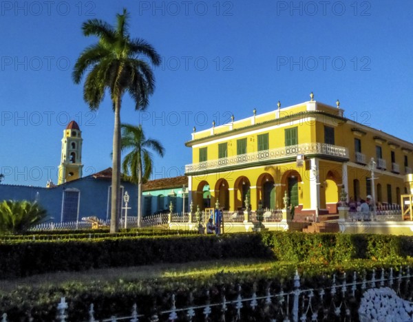Centre of Trinidad Palacio Brunet, yellow palace with blue sky and the church Convento de San Francisco de Asis, Cuba