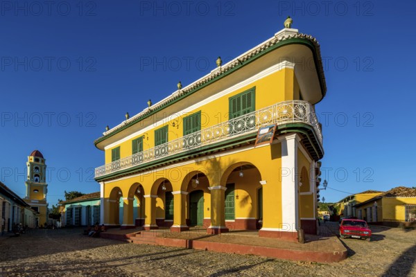 Centre of Trinidad Palacio Brunet, yellow palace with blue sky and the church Convento de San Francisco de Asis, Trinidad, Cuba, Sancti Spíritus, Sancti Spíritus