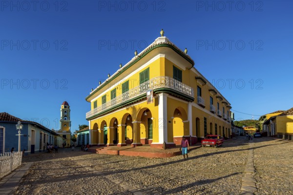 Centre of Trinidad Palacio Brunet, yellow palace with blue sky and the church Convento de San Francisco de Asis, Trinidad, Cuba, Sancti Spíritus, Sancti Spíritus